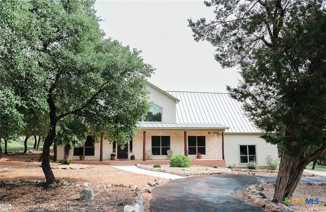 211 Cambridge Dr, New Braunfels, TX 78132 - view of front facade with metal roof, a standing seam roof, stucco siding, and covered porch