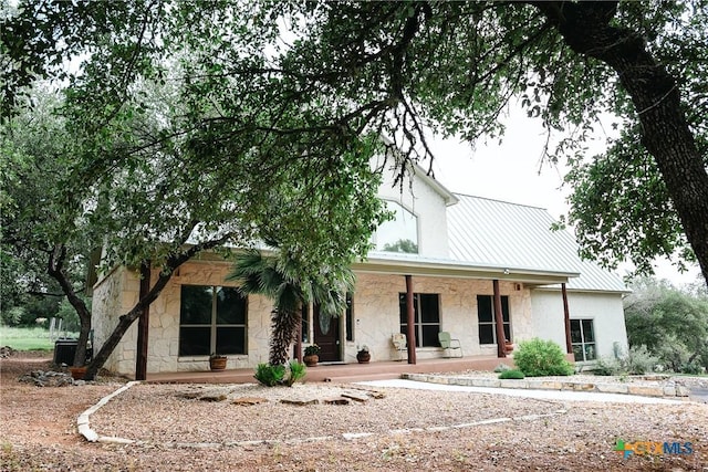211 Cambridge Dr, New Braunfels, TX 78132 - view of front of house featuring stone siding, a standing seam roof, metal roof, stucco siding, and a porch