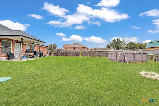 view of yard featuring a fenced in pool and a patio area