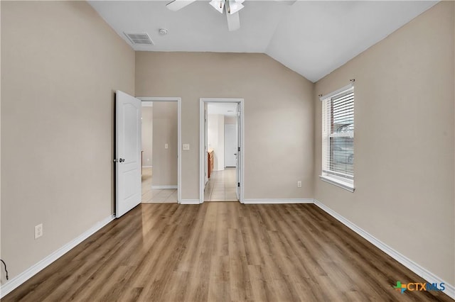 unfurnished bedroom with connected bathroom, vaulted ceiling, ceiling fan, and light wood-type flooring