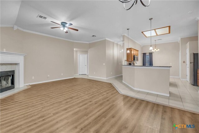 kitchen with appliances with stainless steel finishes, crown molding, sink, a chandelier, and a kitchen island