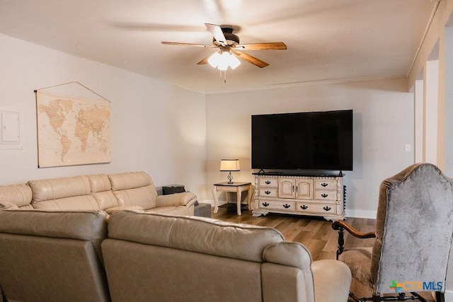 living room featuring baseboards, a ceiling fan, and wood finished floors