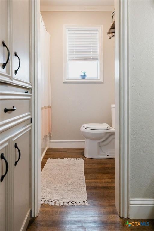 bathroom featuring crown molding, toilet, and wood finished floors