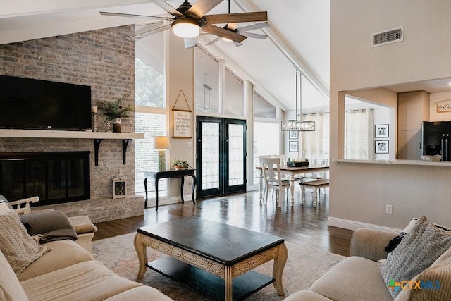 living room featuring wood finished floors, high vaulted ceiling, visible vents, a ceiling fan, and baseboards