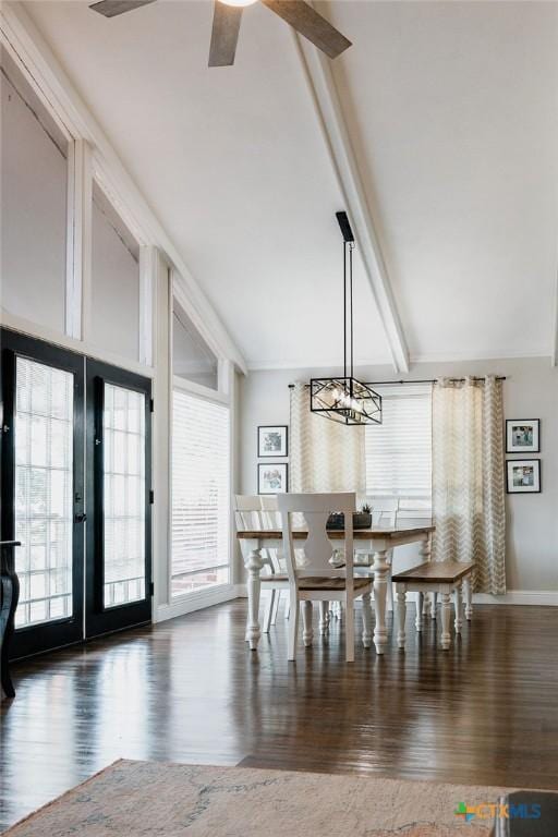 dining area with plenty of natural light, wood finished floors, ceiling fan with notable chandelier, and beam ceiling