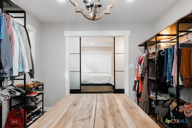 walk in closet featuring an inviting chandelier