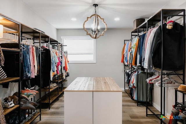 spacious closet with an inviting chandelier and wood finished floors