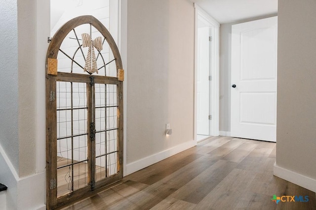 corridor with baseboards, french doors, and wood finished floors