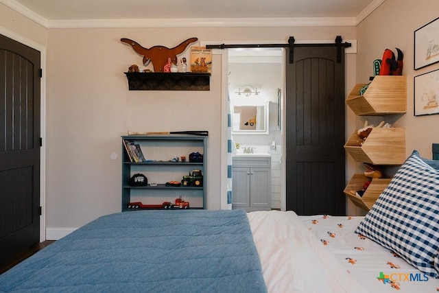 bedroom with a sink, ensuite bathroom, ornamental molding, and a barn door