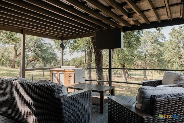 wooden terrace featuring an outdoor structure, outdoor dining space, and a storage shed