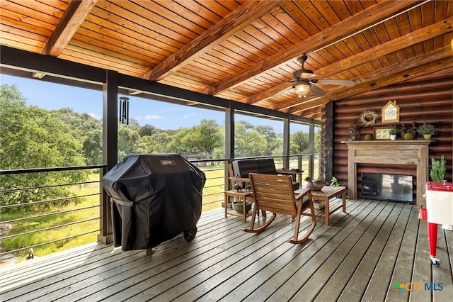 sunroom with a fireplace, a healthy amount of sunlight, ceiling fan, and wooden ceiling