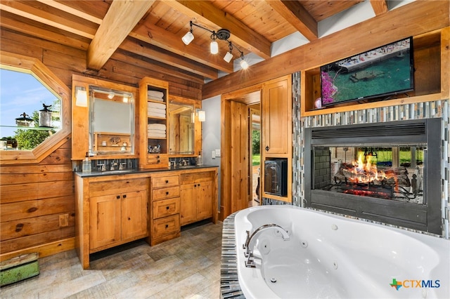 332 Westin Hls, New Braunfels, TX 78132 - full bathroom with wood ceiling with exposed beams, a whirlpool tub, a multi sided fireplace, double vanity, and wood finished floors