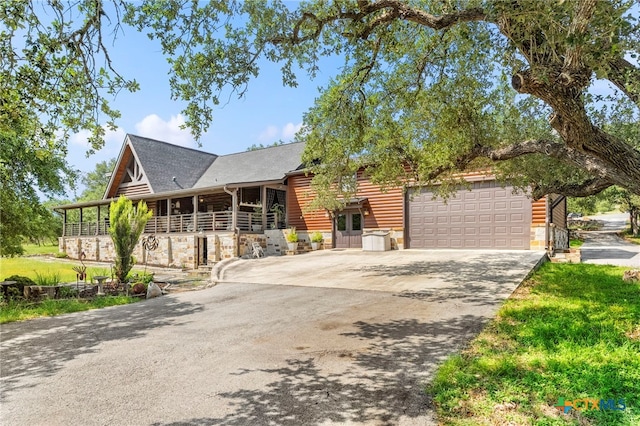 332 Westin Hls, New Braunfels, TX 78132 - view of front of house featuring an attached garage, driveway, stone siding, and log veneer siding