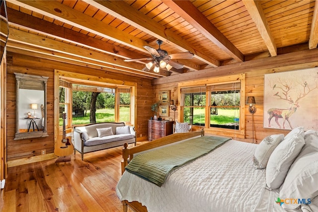 bedroom with wood ceiling, wood-type flooring, multiple windows, and wooden walls