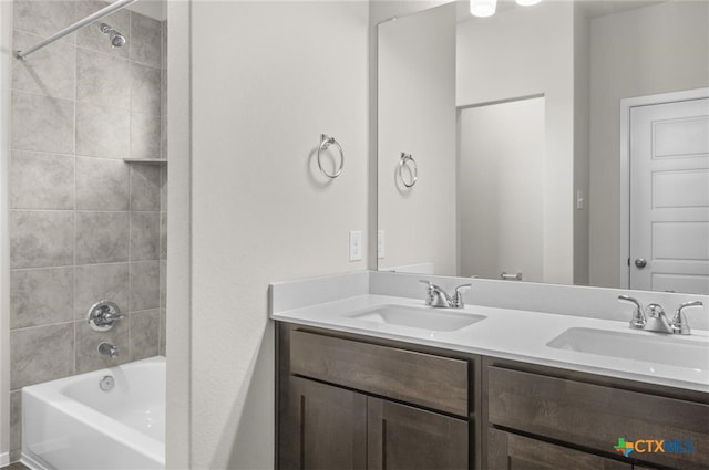 bathroom featuring vanity and tiled shower / bath