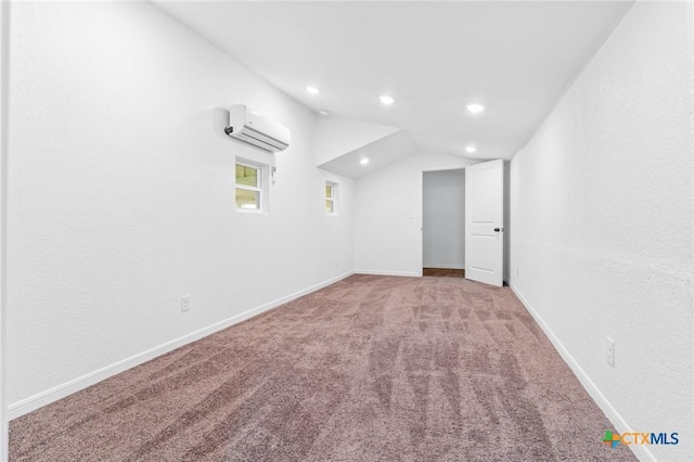 carpeted spare room featuring vaulted ceiling, recessed lighting, a wall mounted air conditioner, and baseboards