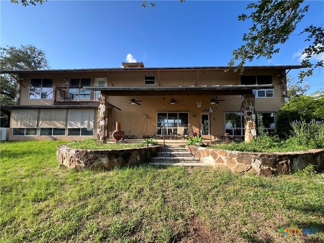 184 Guadalupe Hills Ln, Seguin, TX 78155 - back of house featuring ceiling fan, a lawn, a patio area, and stucco siding