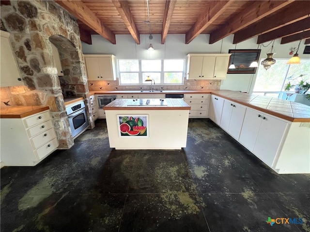 184 Guadalupe Hills Ln, Seguin, TX 78155 - kitchen featuring stainless steel appliances, a wooden ceiling with exposed beams, tasteful backsplash, a peninsula, and a center island