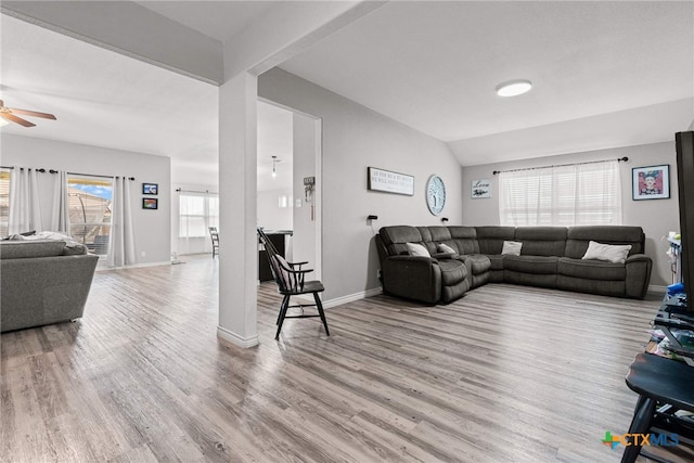 living room with ceiling fan, light hardwood / wood-style floors, and lofted ceiling