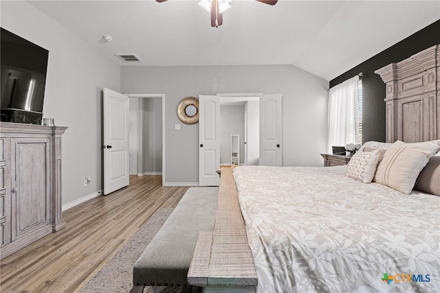 bedroom with ceiling fan, vaulted ceiling, and light wood-type flooring