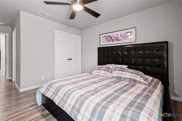 bedroom with ceiling fan, a closet, and hardwood / wood-style flooring