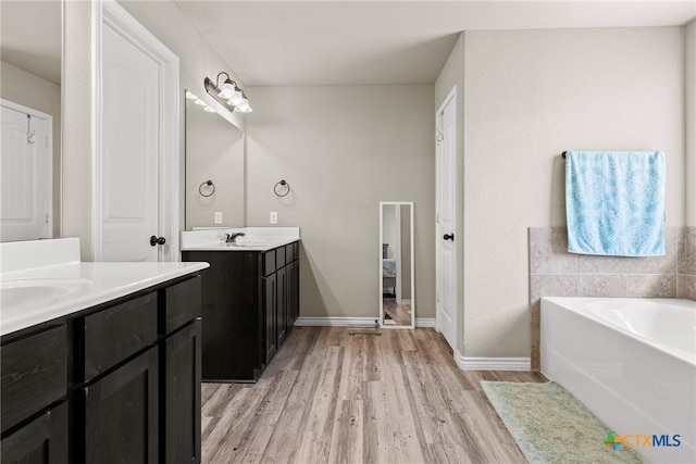 bathroom featuring hardwood / wood-style floors, vanity, and a tub