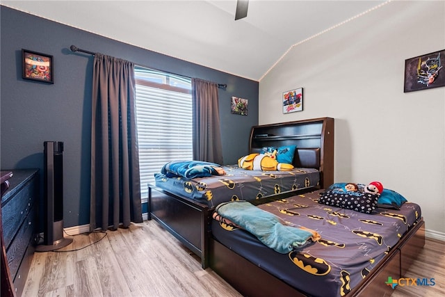 bedroom with hardwood / wood-style floors, vaulted ceiling, and ceiling fan