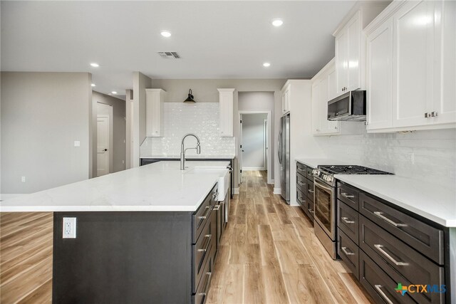 kitchen featuring light hardwood / wood-style flooring, white cabinets, and stainless steel appliances