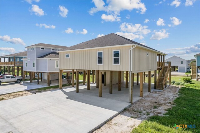 back of house featuring a carport