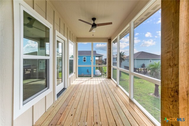 unfurnished sunroom featuring a wealth of natural light and ceiling fan