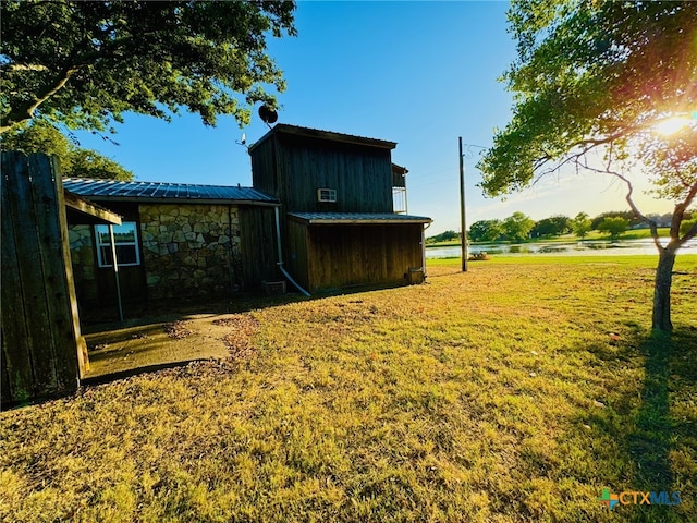 exterior space featuring a yard and a water view