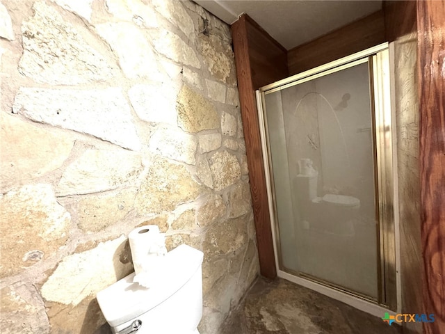 bathroom featuring toilet and an enclosed shower