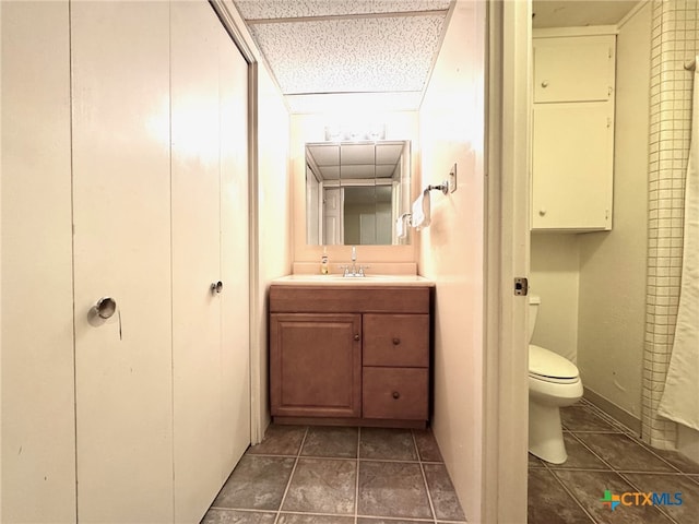 bathroom featuring vanity, tile patterned floors, and toilet