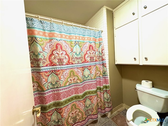 bathroom featuring a shower with shower curtain, tile patterned flooring, and toilet