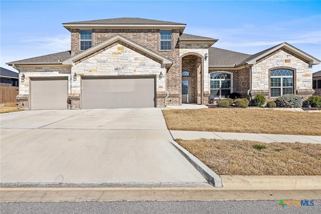 view of front of home with brick siding, roof with shingles, an attached garage, a front yard, and driveway