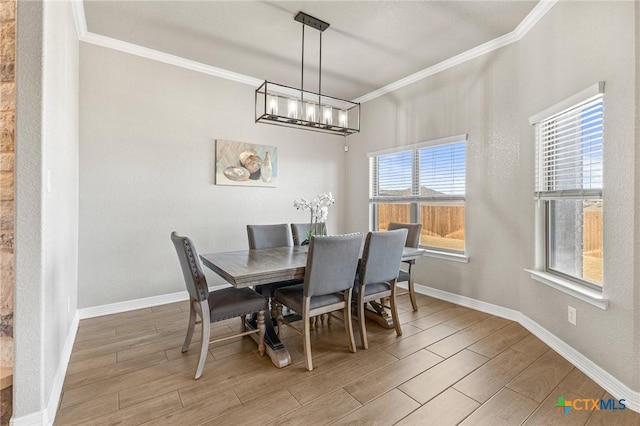 dining area with baseboards, ornamental molding, and wood tiled floor