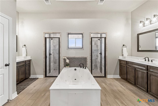 full bathroom with a stall shower, wood finished floors, and visible vents