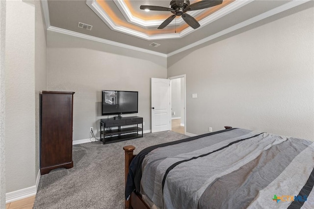 carpeted bedroom featuring a raised ceiling, visible vents, crown molding, and baseboards