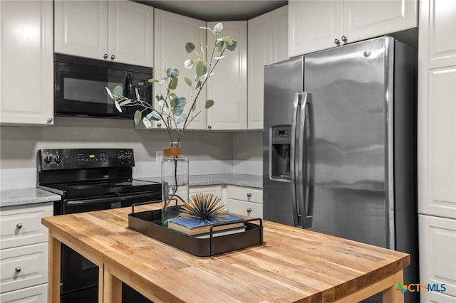 kitchen featuring white cabinets, butcher block counters, and black appliances