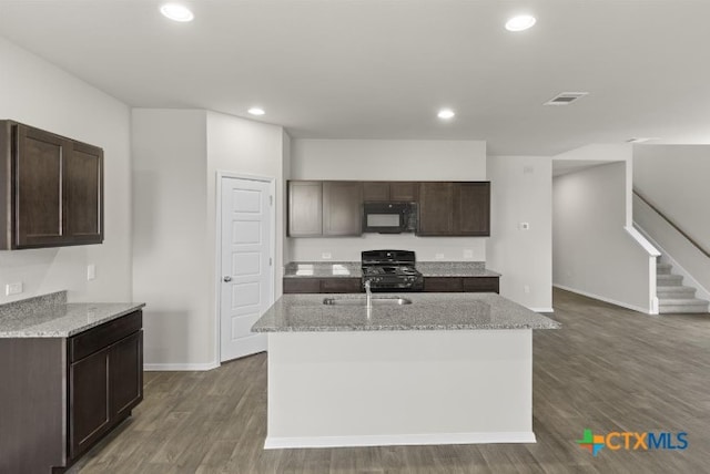 kitchen with a kitchen island with sink, sink, black appliances, and dark hardwood / wood-style floors