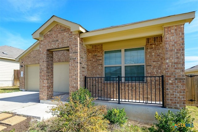 view of front of property with concrete driveway, brick siding, and an attached garage