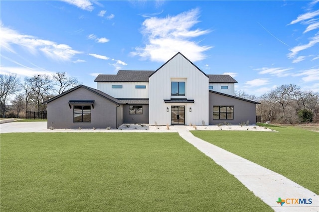 modern farmhouse with a front lawn and roof with shingles