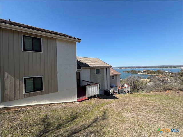 view of side of property with a yard and a water view