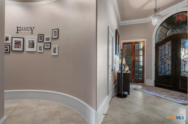 entryway with light tile patterned flooring, crown molding, and french doors