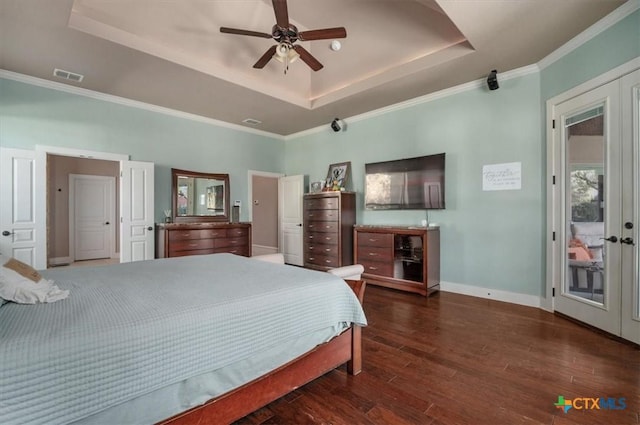 bedroom with ceiling fan, a tray ceiling, dark wood-type flooring, french doors, and crown molding