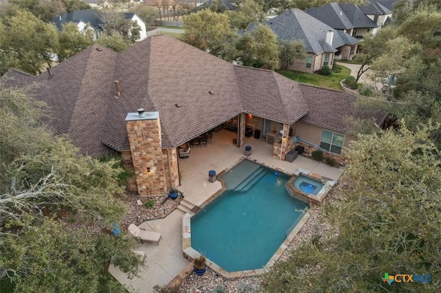 view of pool featuring a patio and an in ground hot tub