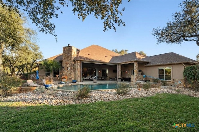 back of house with a yard and a patio