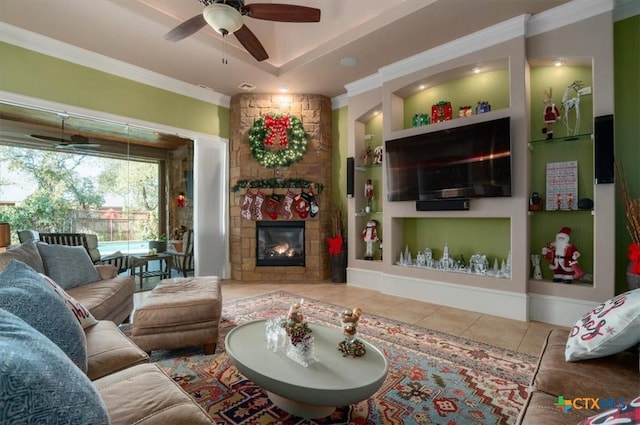 living room with tile patterned floors, a fireplace, built in features, ceiling fan, and crown molding