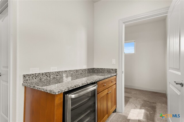 1607 Filtro, New Braunfels, TX 78132 - kitchen with beverage cooler, light colored carpet, brown cabinetry, and stone counters