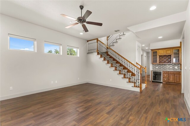 1607 Filtro, New Braunfels, TX 78132 - unfurnished living room with wet bar, stairs, recessed lighting, dark wood-style flooring, and beverage cooler